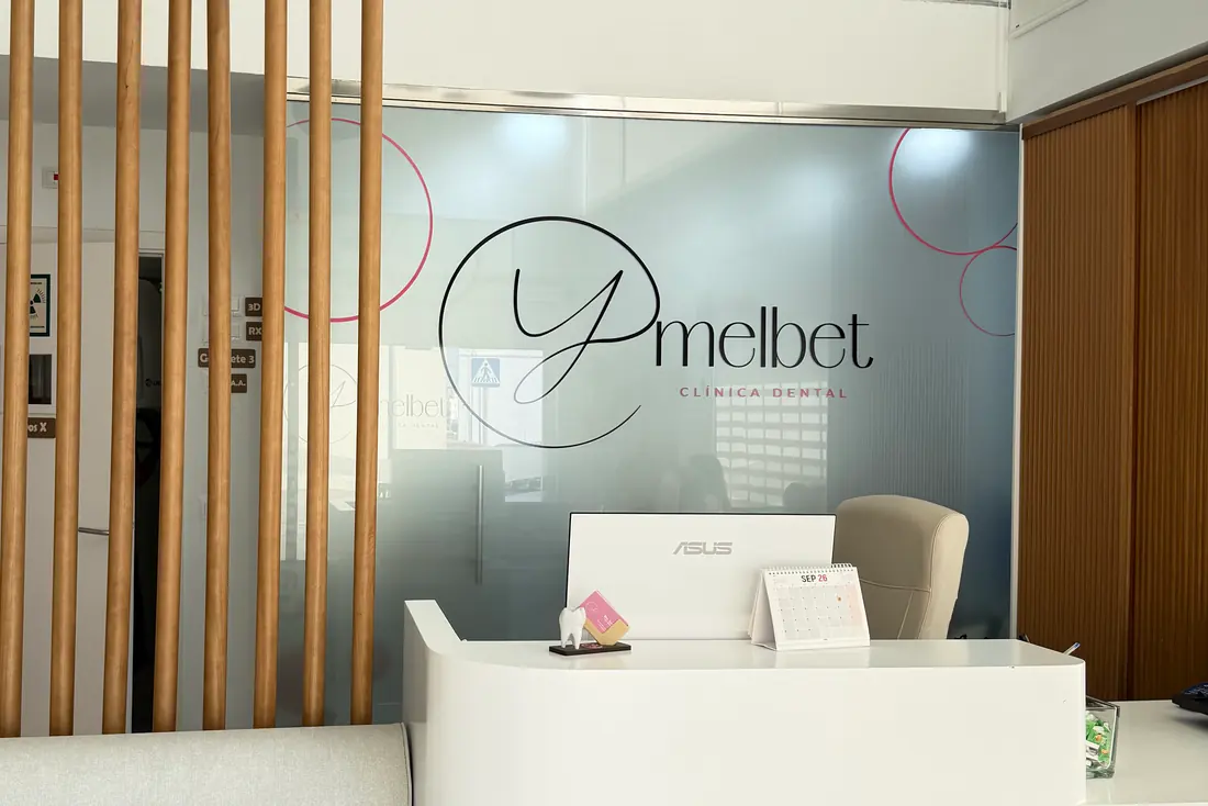 Recepción de la Clínica Dental Ymelbet, con el logotipo en la pared